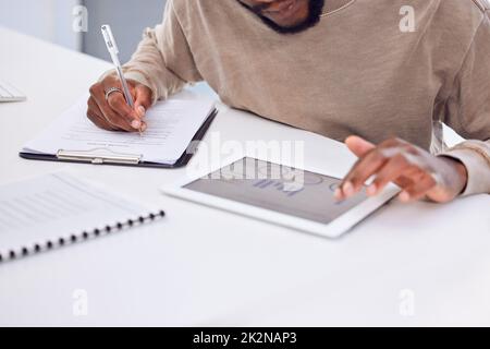 Les chiffres sont bons. Photo rognée d'un homme d'affaires à l'aide d'une tablette numérique tout en remplissant quelques documents. Banque D'Images