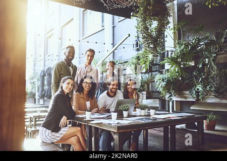 Nous préférons nos réunions dans un cadre détendu. Portrait d'un groupe de collègues ayant une réunion dans un café. Banque D'Images