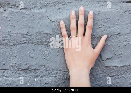 Le symbole de l'engagement. Coupe courte d'un anneau d'engagement sur une main de femme méconnaissable. Banque D'Images