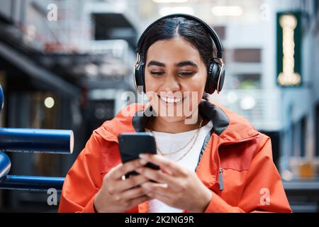 Enregistrement avec des amis. Photo d'une jeune étudiante en utilisant un téléphone à l'université. Banque D'Images