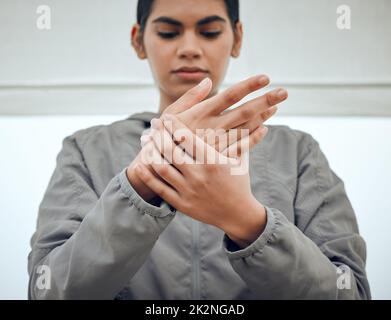 Sûrement, il ne peut pas être l'arthrite à mon âge. Prise de vue courte d'une jeune femme attirante tenant son poignet dans la douleur tout en étant assise à l'extérieur. Banque D'Images