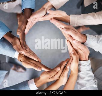 La solidarité fait le tour du monde. Photo d'un groupe d'hommes d'affaires qui se joignent à eux en solidarité. Banque D'Images