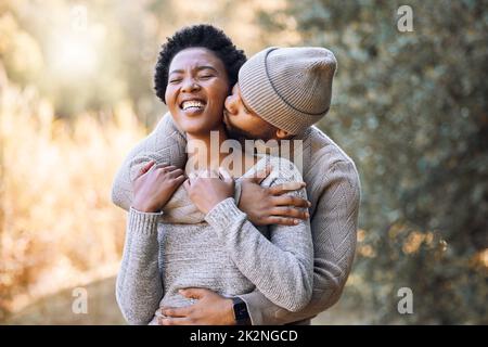 Rien n'est plus unique... passer du temps avec vous. Photo d'un jeune homme embrassant sa petite amie lors d'un voyage en camping. Banque D'Images