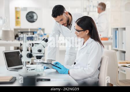 Partager des points de vue sur les découvertes de l'époque. Photo de deux scientifiques travaillant ensemble dans un laboratoire. Banque D'Images