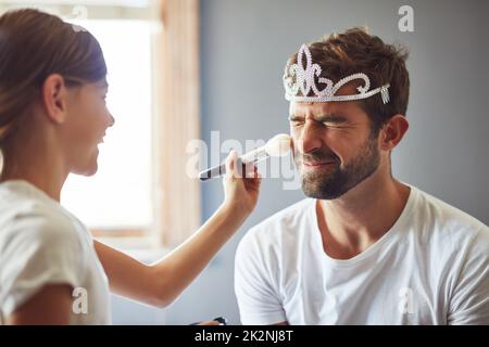 J'aime que Daddy joue habiller avec moi. Photo courte d'une petite fille mettant le maquillage sur son père. Banque D'Images