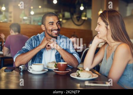 Cet endroit est incroyable - j'aurais bien aimé le découvrir plus tôt. Photo d'un jeune couple sur une date dans un café. Banque D'Images