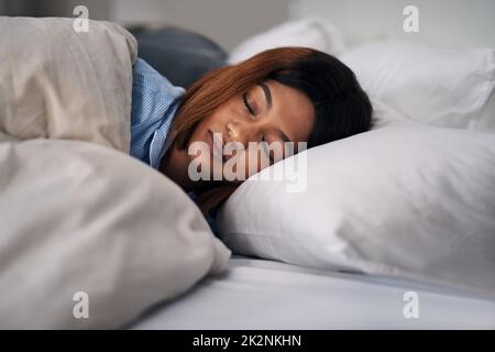 Ça me plaît. Plan court d'une jeune femme attrayante dormant paisiblement dans le lit à la maison. Banque D'Images