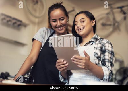 Regardez-les s'obscurcissement par-dessus le rouge à lèvres. Prise de vue de deux jeunes femmes utilisant une tablette numérique au travail. Banque D'Images