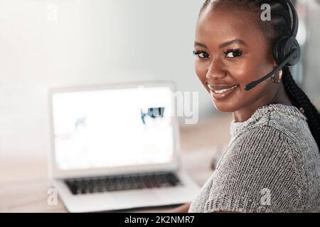 Si vous avez besoin de quelque chose de theres, il faut être ici. Photo d'une jeune femme utilisant un casque et un ordinateur portable dans un bureau moderne. Banque D'Images