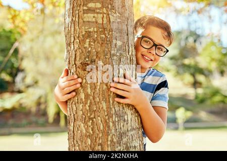 Je pense que j'ai trouvé un endroit très bien caché. Portrait d'un petit garçon jouant au parc. Banque D'Images