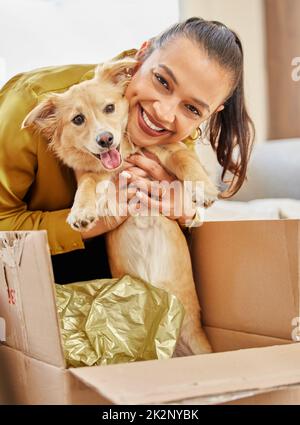 Dites bonjour à mon nouveau-né. Photo d'une jeune femme assise à la maison avec un adorable petit chien. Banque D'Images