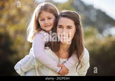 Rien ne vaut un peu de temps de qualité. Portrait court d'une jeune femme attrayante et de sa fille posant à l'extérieur dans le jardin à la maison. Banque D'Images