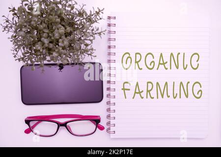 Symbole de texte indiquant Agriculture biologique. Présentation commerciale un système agricole intégré qui s'efforce de garantir la durabilité des fournitures de bureau sur le bureau avec clavier et lunettes et une tasse à café pour travailler Banque D'Images