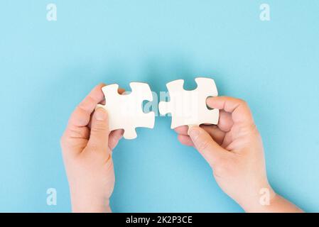 Tenir deux pièces d'un puzzle entre les mains, se connecter en équipe, résoudre un problème, la stratégie et le concept de communication Banque D'Images