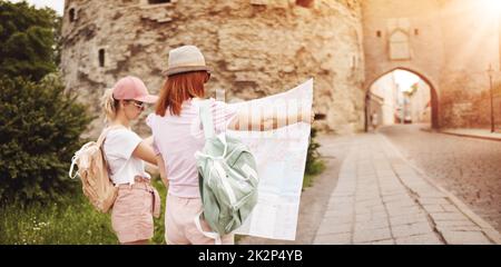 Deux femmes à la recherche de l'emplacement des sites touristiques sur la carte de la vieille Tallinn, Estonie. Banque D'Images