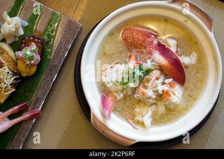 Homard nabe dans une casserole en céramique servi avec des sushis sur la table. Vue de dessus Banque D'Images