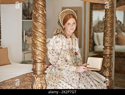 Ma place loin du terrain. Portrait d'une élégante noble femme lisant dans sa salle de palais. Banque D'Images