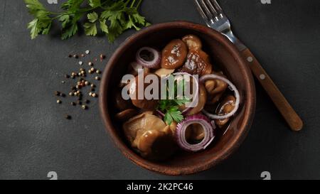 Champignons salés, Lactarius resimus, récolte d'automne. Champignons marinés marinés, oignons rouges, poivrons, ail et feuilles de Laurier. Lactarius resimus salé avec de l'huile et de l'aneth frais haché Banque D'Images