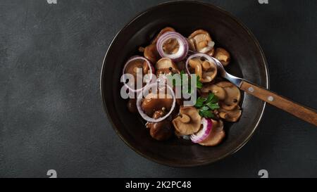 Champignons salés, Lactarius resimus, récolte d'automne. Champignons marinés marinés, oignons rouges, poivrons, ail et feuilles de Laurier. Lactarius resimus salé avec de l'huile et de l'aneth frais haché Banque D'Images