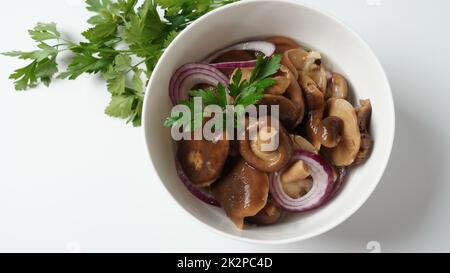 Champignons salés, Lactarius resimus, récolte d'automne. Champignons marinés marinés, oignons rouges, poivrons, ail et feuilles de Laurier. Lactarius resimus salé avec de l'huile et de l'aneth frais haché Banque D'Images