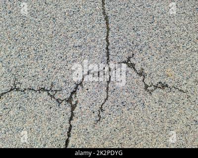 Les surfaces asphaltées des rues et des routes endommagées présentent des fissures en gros plan. Banque D'Images