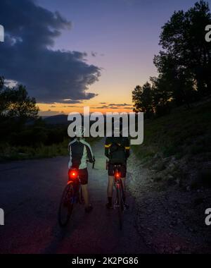 Deux cyclistes sur une promenade de nuit dans les Alpilles, San Remy de Provence, France. Banque D'Images