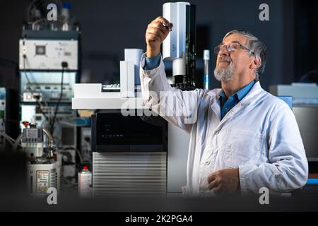 Chercheur principal dans un laboratoire de chimie qui effectue des recherches : analyse d'échantillons de chromatographie en phase gazeuse, préparation de l'analyse sur un chromatographe en phase gazeuse moderne (image colorée) Banque D'Images