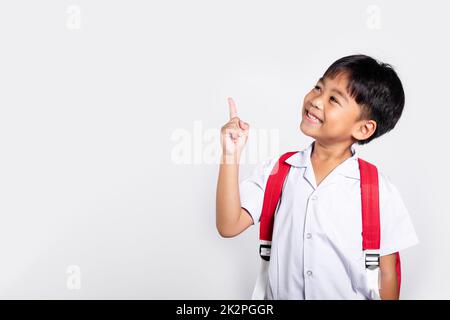 Asiatique tout-petit sourire Happy Wear étudiant thaïlandais uniforme pantalon rouge continue de pointer le doigt sur l'espace de copie Banque D'Images