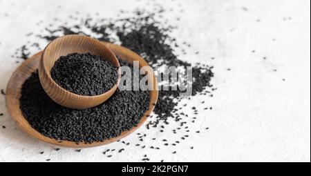 Épices indiennes graines de cumin noir (nigella sativa ou kalonji) dans des bols en bois gros plan Banque D'Images