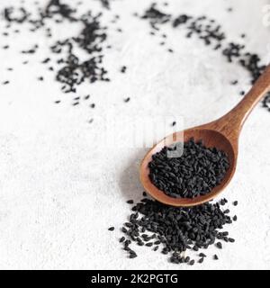 Cuillère en bois de graines de cumin noir d'épices indiennes (nigella sativa ou kalonji) gros plan Banque D'Images