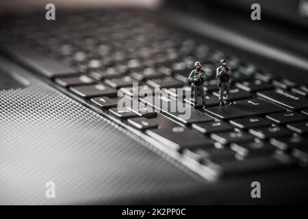 L'équipe swat miniature protéger un ordinateur portable. Technologie concept Banque D'Images