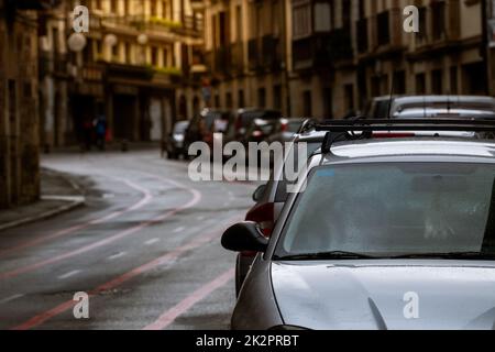 Rangée de voitures garées le long de la rue et de vieux bâtiments dans la ville d'Europe. Beaucoup de voitures garées sur la route dans la vieille ville. Rue de ville en Europe. Vue avant de la voiture garée à l'extérieur du bâtiment résidentiel. Circulation urbaine. Banque D'Images