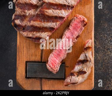 Steak de filet de bœuf grillé aux herbes et aux épices sur une table sombre en gros plan Banque D'Images