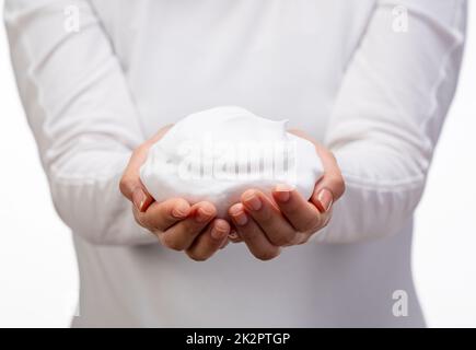 Femme tenant des bulles de savon sur fond blanc. Banque D'Images