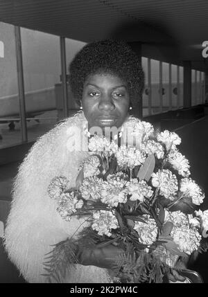 Nina Simone à l'aéroport de Schiphol portant un bouquet de fleurs photographié par Jack de Nijs pour Anefo - 1969 Banque D'Images