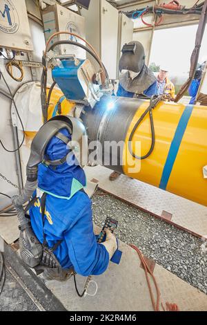 23 September 2022, Schleswig-Holstein, Brunsbüttel: Two welders in a welding tent weld pipes together on the pipeline for the planned floating liquefied natural gas terminal. Photo: Georg Wendt/dpa Stock Photo