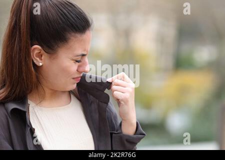 Une femme se plaint d'une mauvaise odeur de vêtements Banque D'Images