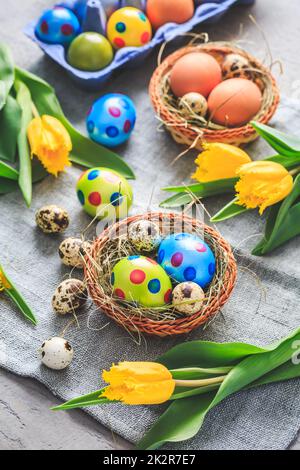 Oeufs de Pâques et tulipes sur fond gris Banque D'Images