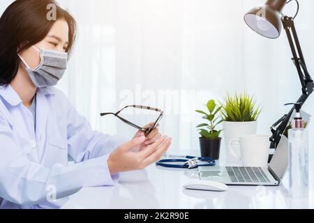 Médecin femme porter un masque de protection vidéo appel conférence en ligne parler aux patients Banque D'Images