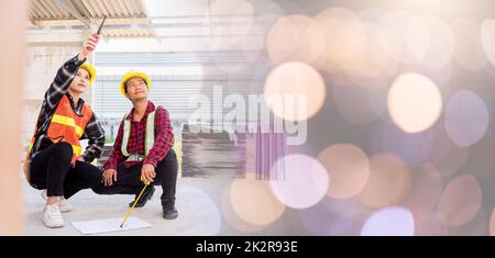 L'architecte et le client discutent de l'aide à la création d'un plan avec le plan du bâtiment sur le chantier de construction. Un homme et une femme de travail de contremaître d'ingénieur asiatique se rencontrent pour discuter du projet de papier à dessin, travail d'équipe Banque D'Images