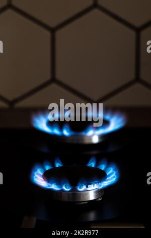 Gros plan de feu bleu de la cuisine domestique dessus de cuisinière. Combustion de gaz, brûleur de cuisinière à gaz. Cuisinière à gaz avec flammes de gaz propane. Concept des ressources industrielles et de l'économie. Banque D'Images