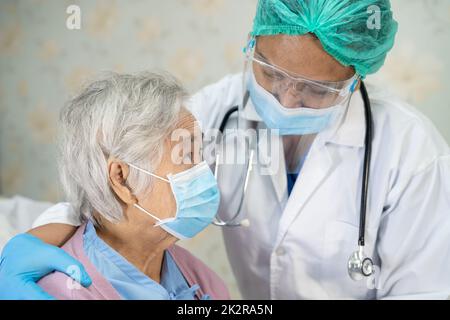 Médecin vérifiant asiatique senior ou âgée vieille femme patiente portant un masque facial à l'hôpital pour protéger l'infection Covid-19 coronavirus. Banque D'Images