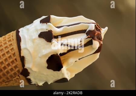 Un gros plan d'un délicieux cône de glace avec gaufres, glace à la vanille et glaçage au chocolat. Banque D'Images