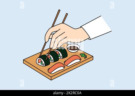 La personne tient des baguettes mangeant des sushis Banque D'Images