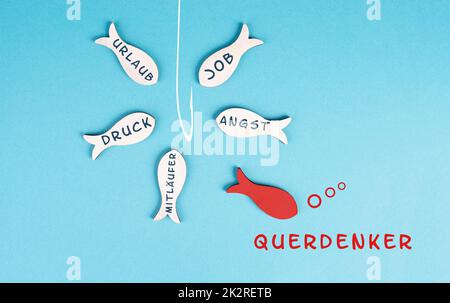 Groupe de poissons avec des mots comme la peur, la pression, la nage de suiveur à la canne de pêche, le poisson rouge prend sa propre décision, prend une direction différente, contre le cours d'eau, la langue allemande Banque D'Images