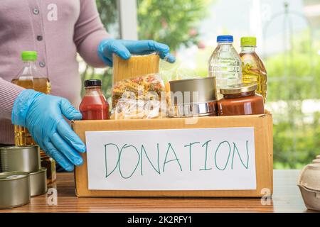 Produits alimentaires pour le don, l'entreposage et la livraison. Divers aliments, pâtes, huile de cuisson et conserves dans une boîte en carton. Banque D'Images