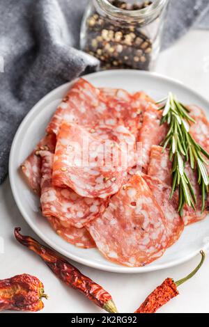 Saucisse italienne de salami en tranches avec du poivre sur l'assiette. Banque D'Images