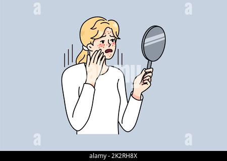 Femme malheureuse regarder dans le miroir se soucier de l'acné Banque D'Images