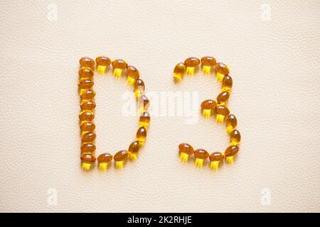 Pilules jaune d'huile brillante formant la forme D3. Capsules de vitamine D3. Vitamines de médecine et compléments alimentaires. Mise au point sélective. Banque D'Images