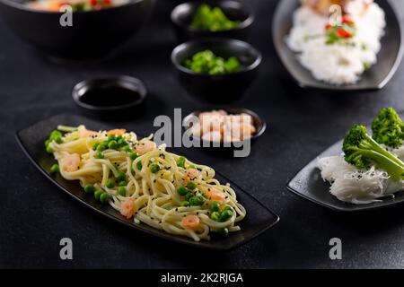 Divers plats de cuisine asiatique avec différents types de nouilles et de riz aux crevettes, canard, légumes et sésame noir Banque D'Images